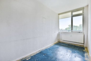 Mavi zemini olan boş ve parlak bir oda.