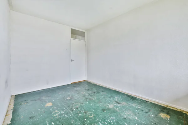 Um quarto vazio e luminoso com um piso verde — Fotografia de Stock