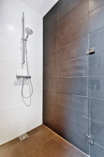 Cabine de duche em estilo minimalista com uma parede de azulejos castanhos — Fotografia de Stock