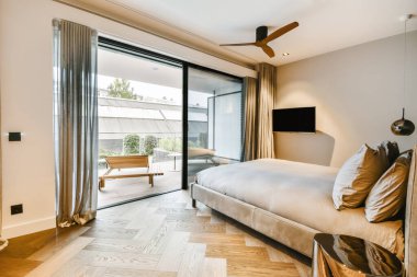 Minimalist tarzda, yumuşak, çift kişilik yataklı çekici bir yatak odası.