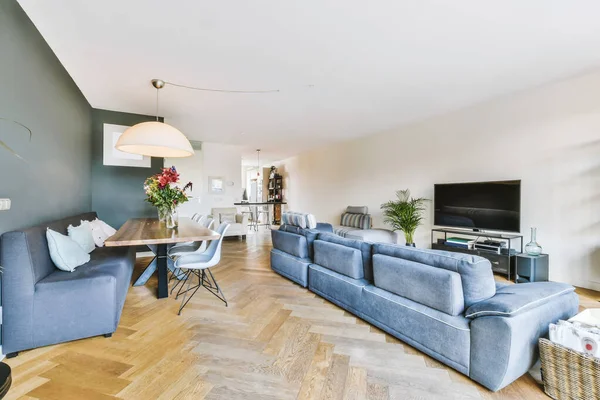 Uma deliciosa sala de estar com um grande sofá azul — Fotografia de Stock