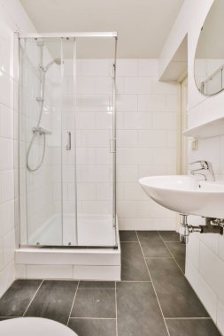 Siyah döşemeli göz kamaştırıcı bir banyo.