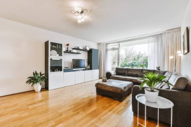 Büyük siyah bir kanepesi olan şık bir oturma odası.