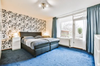 Mavi halılı şık bir yatak odası.