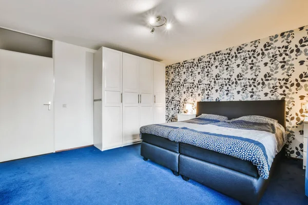 Stijlvolle slaapkamer met blauw tapijt — Stockfoto