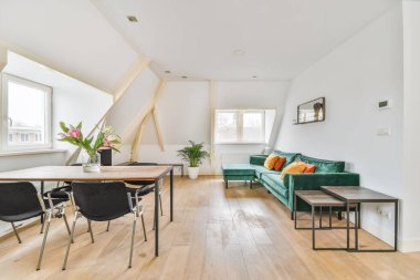 Dekoratif yastıklı zümrüt kanepeli çekici bir oturma odası.