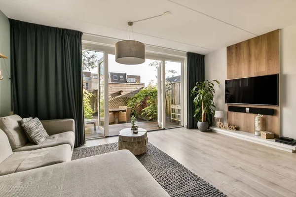 Living room with a corner sofa in front of a large TV