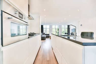 Siyah bir tezgahı olan muhteşem bir mutfağın içi.