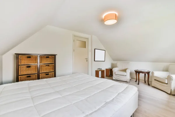 A belső tér egy gyönyörű hálószoba egy puha ágy borított fehér takaró — Stock Fotó