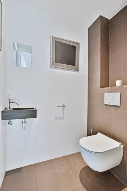 Küçük siyah lavabosu olan minimalist bir banyo.