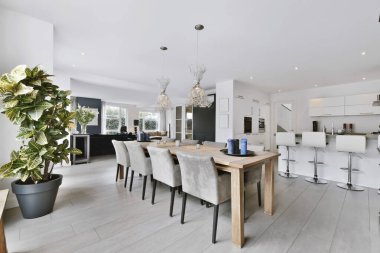 İki avizesi olan minimalist bir yemek odası.