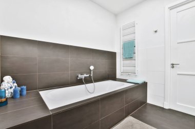Banyo minimalist tarzda ve rahat bir küveti var.