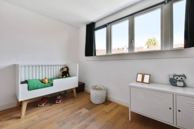 Beyaz bebek yatağı olan güzel bir çocuk odası.