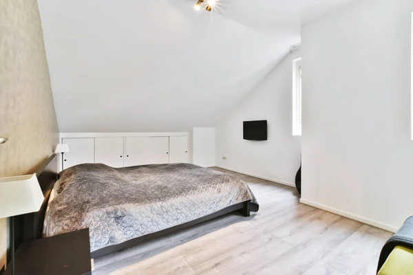 Chambre confortable avec un lit couvert d'une couverture grise — Photo