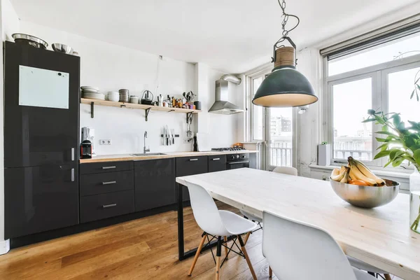 Хорошая кухня с черным кухонным набором и деревянной столешницей — стоковое фото