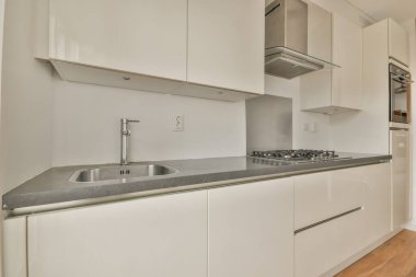 Beyaz tonlarda küçük bir mutfağın içi.