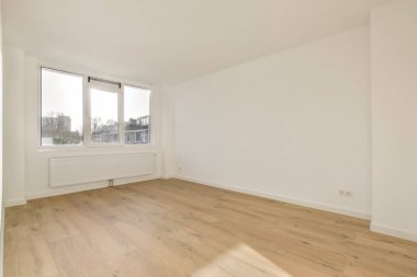 Geniş pencereli, boş bir oda.