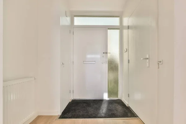 Um corredor branco estreito com tapete — Fotografia de Stock