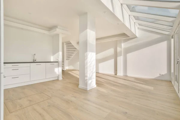 Um grande quarto espaçoso com uma pequena cozinha e uma escadaria — Fotografia de Stock