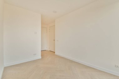 Beyaz tonlarda, küçük, boş bir oda.