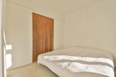 Beyaz tonlarda küçük bir yatak odası.