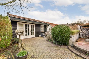 Tuğladan yolları, bitkileri olan bir bahçe.