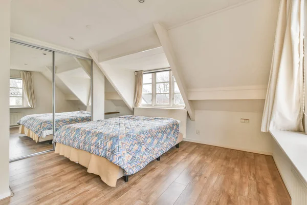 Une chambre avec un petit lit et une armoire en miroir — Photo