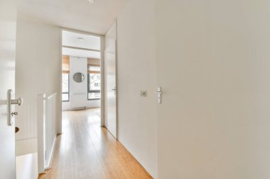 Merdivenleri olan ferah, parlak bir koridor.