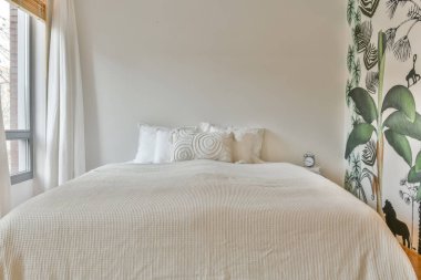 Geniş beyaz yataklı geniş bir yatak odası.