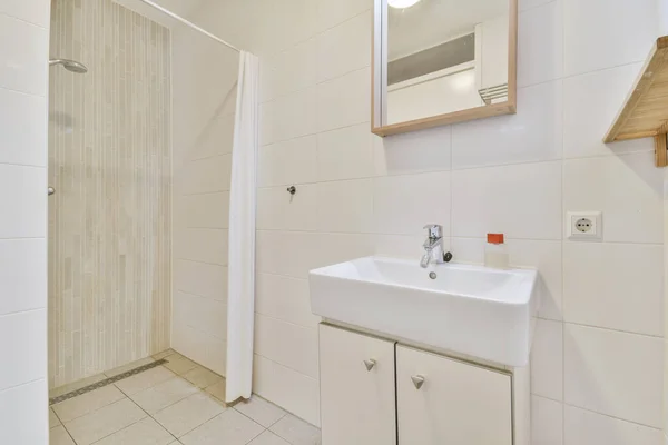 Interior do banheiro terminou com azulejos brancos com uma pia — Fotografia de Stock