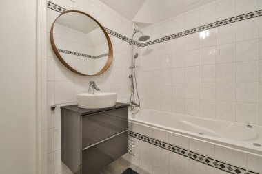 Banyo içinde beyaz fayanslar ve bir desen var.