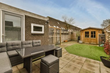 Oturma alanı ve küçük bir çimenliği olan rahat bir bahçe.