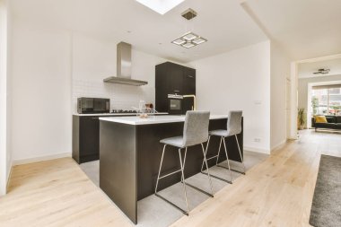 Kahvaltı barı ve modern ekipmanları olan rahat bir mutfağın içini.