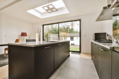 Kahvaltı barı ve modern ekipmanları olan rahat bir mutfağın içini.