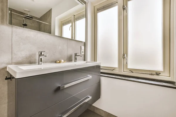 Marble bathroom with a small window and ceramic sink — ストック写真