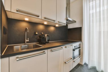 Minimalist tarzda bir köşedeki mutfağın iç kısmı.
