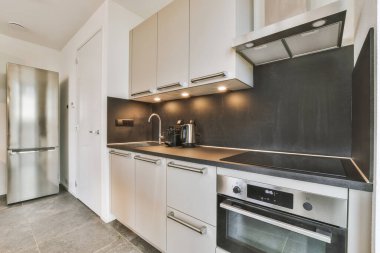Minimalist tarzda bir köşedeki mutfağın iç kısmı.