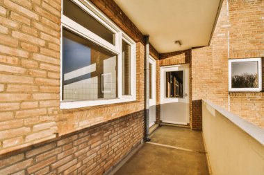 Beton çitli tuğla bir binanın balkonunda.