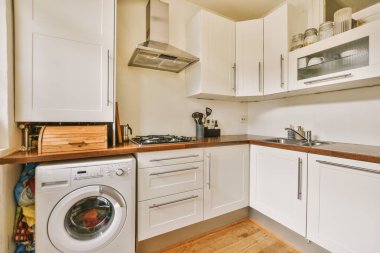 Bir sürü dolabı olan beyaz tasarım modern mutfak.