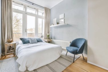 Büyük beyaz yataklı rahat bir yatak odası.