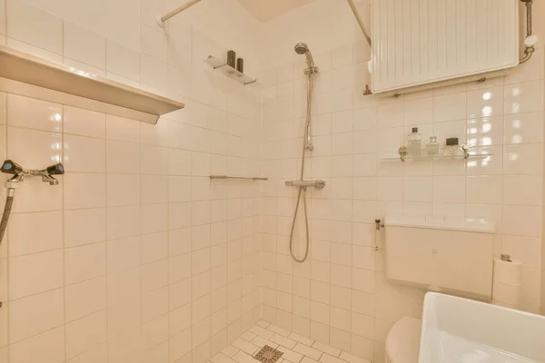 O interior de um banheiro decorado com azulejos brancos — Fotografia de Stock