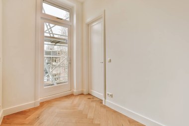 Beyaz tonlu parke zemini olan geniş bir oda.