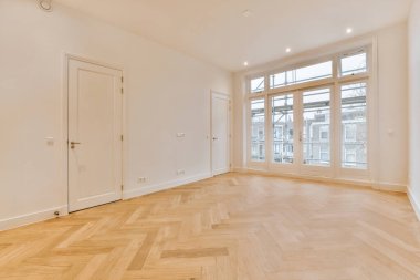 Beyaz tonlu parke zemini olan ferah bir oda.