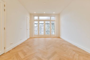 Beyaz tonlu parke zemini olan ferah bir oda.