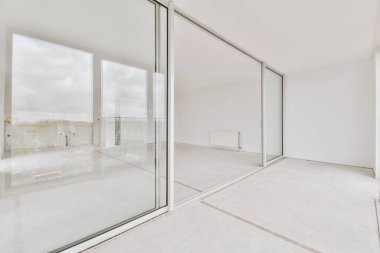 Geniş, boş, parlak balkona erişimi olan bir oda.