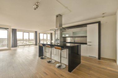 Köşedeki mutfakta beyaz bir bar var.