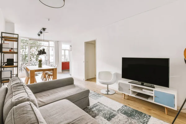 Oturma odası, kanepe, televizyon ve yemek salonu.