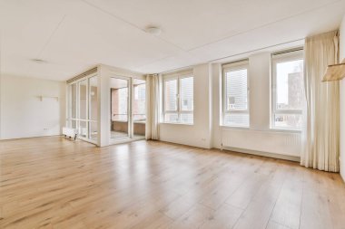 Geniş, parlak, balkona erişimi olan boş bir oda.