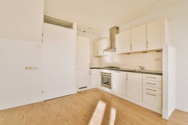 Köşedeki mutfağı olan geniş boş bir oda.