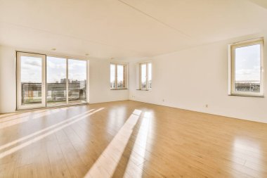 Balkona erişimi olan geniş boş bir oda.